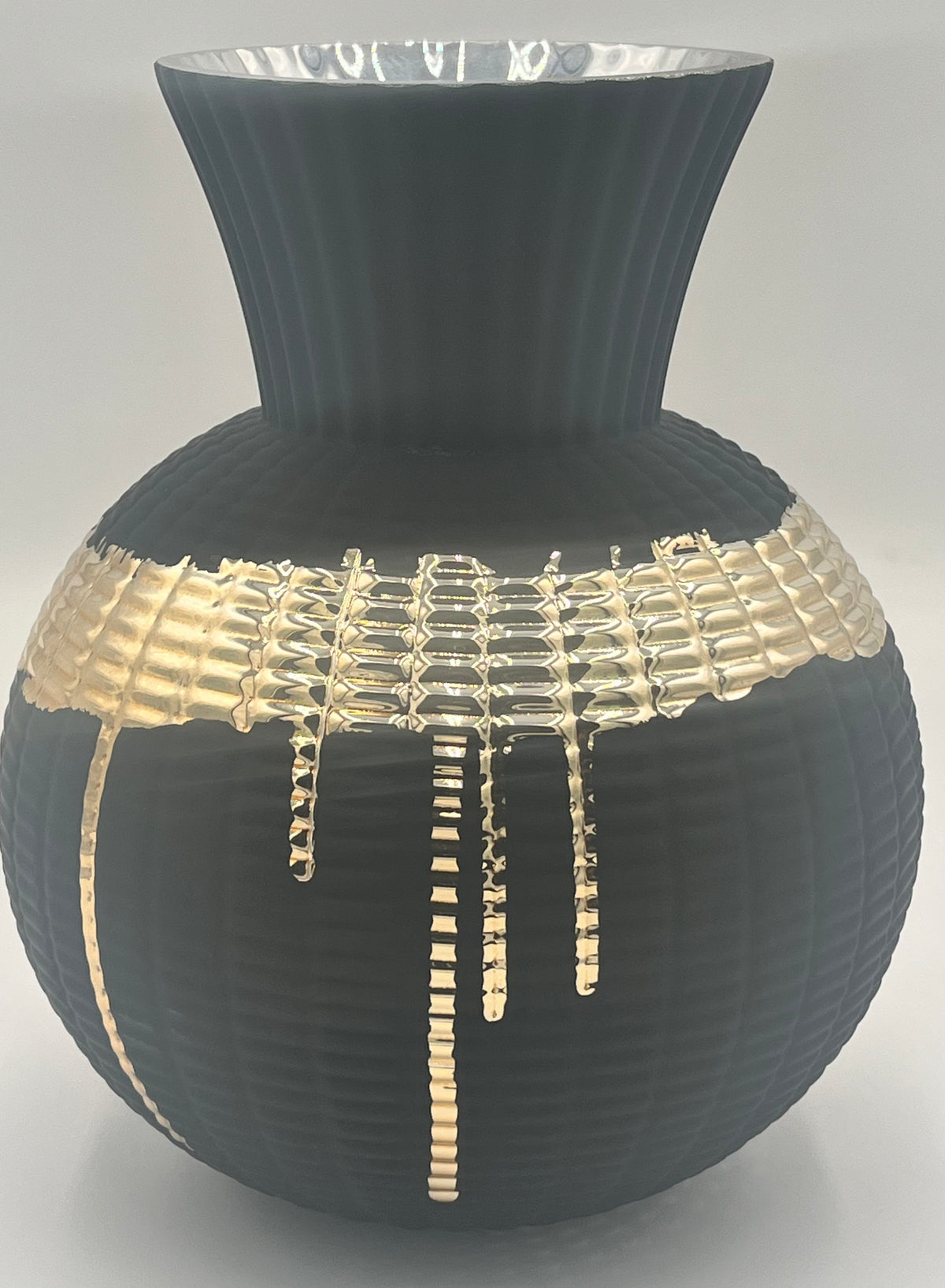 The Obsidian Pour 9.5x4 Op vase by Floral Supplies Point features matte black ribbed texture, a wide flared rim, and a molten gold glaze dripped in an irregular grid across the middle for striking contrast.