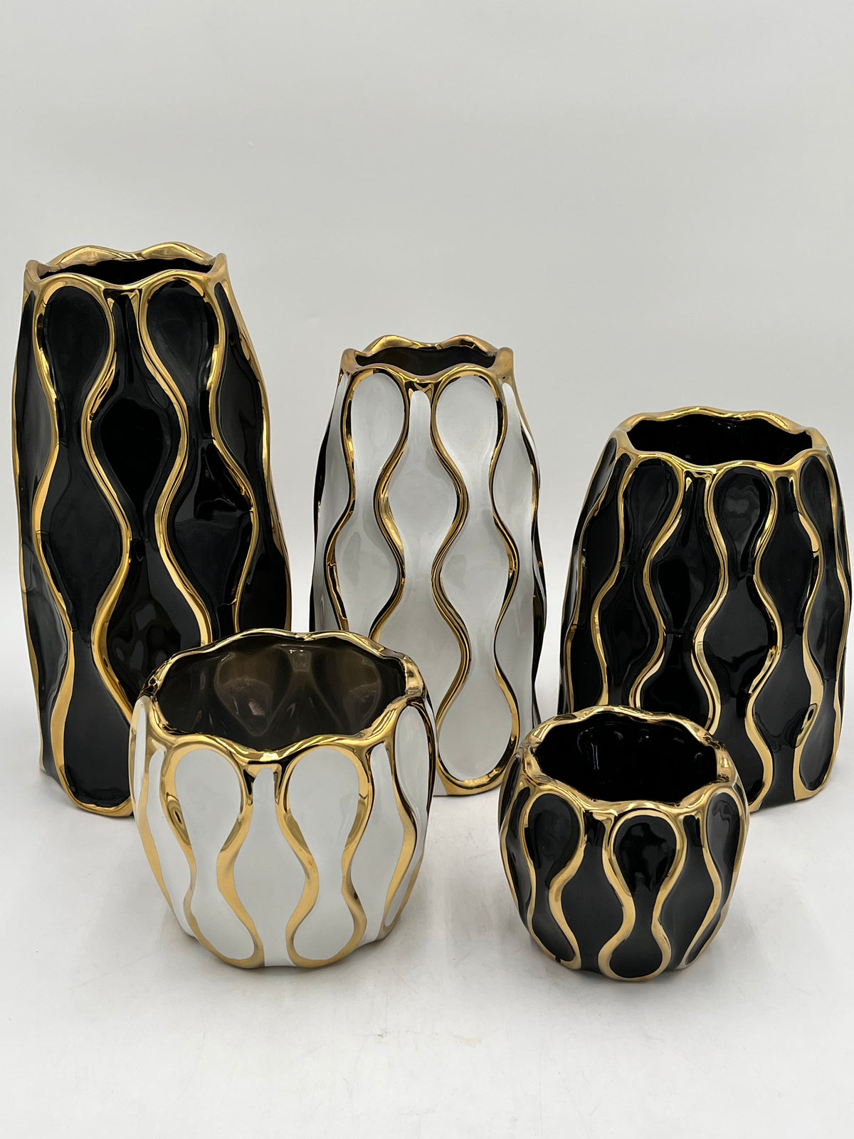 Auric Wave ceramic vases in black & white with gold wave detailing. Elegant décor accent pieces available in 5 sizes & sold by floralsuppliespoint1.com.