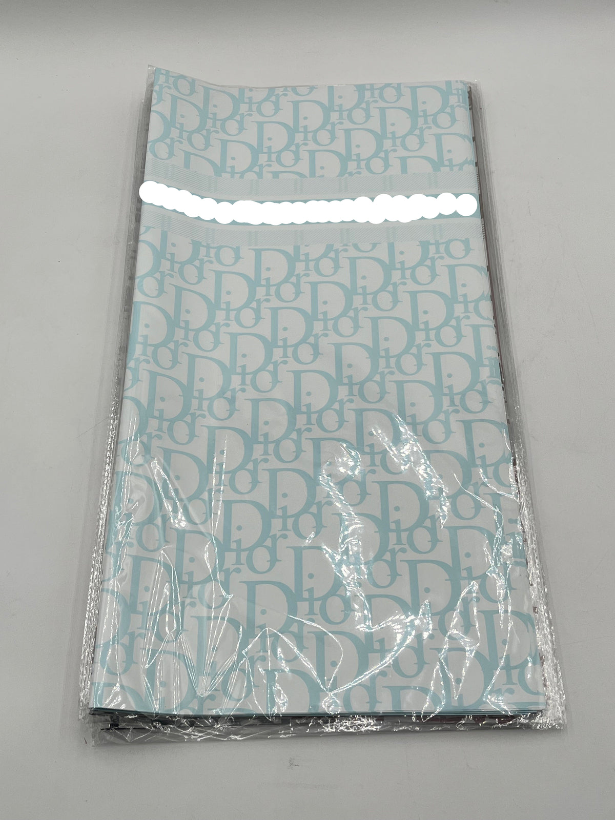 22x22 inch floral wrapping paper with iconic CD monogram in Light Blue.Sold by floralsuppliespoint1.com for $9.99