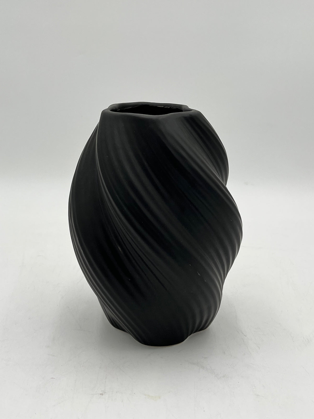Decorative ceramic vase with a modern spiral design, perfect for elegant and minimalist interiors. Sold by floralsuppliespoint1.com for $10.99 in black