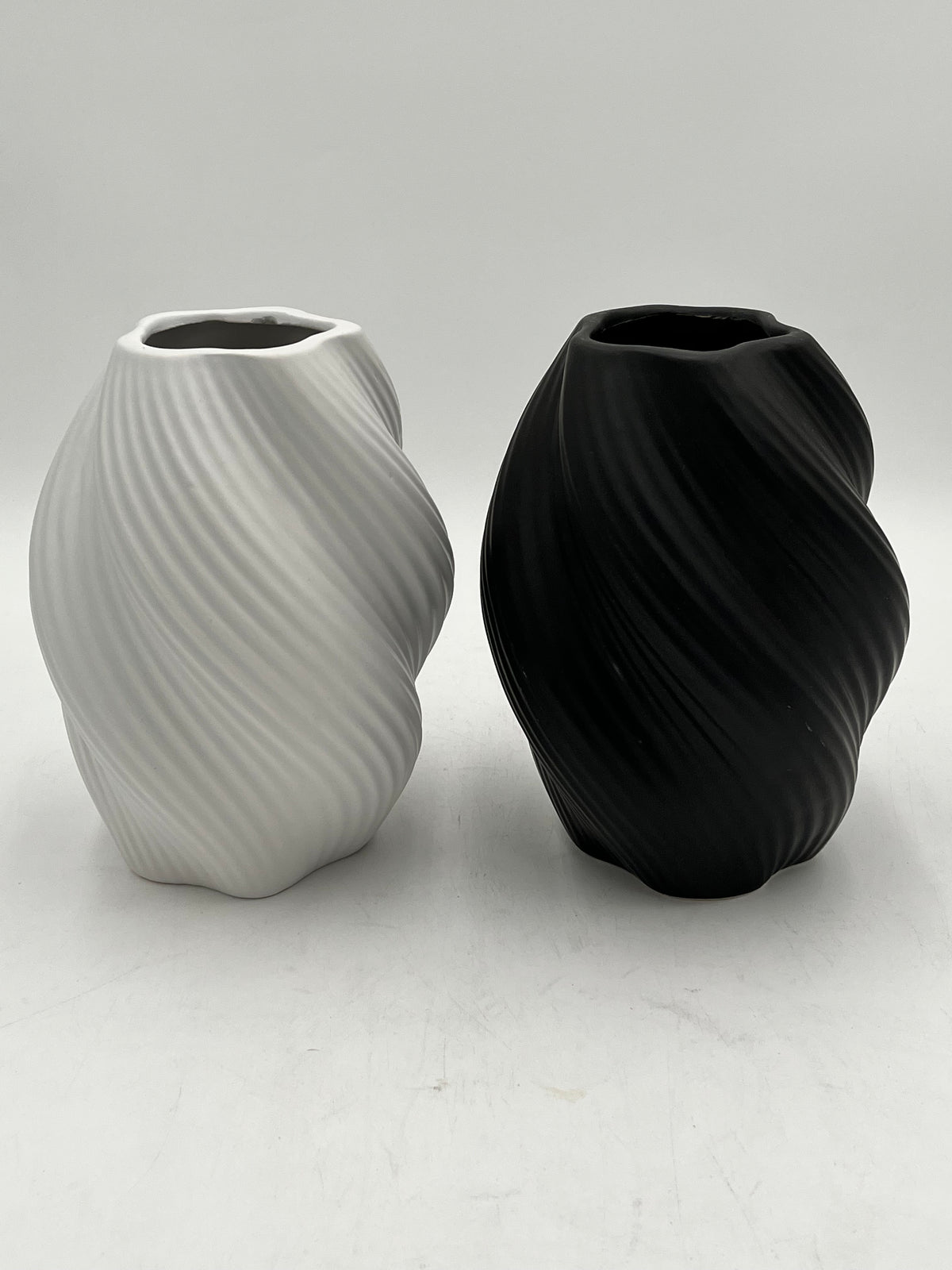 Decorative ceramic vase with a modern spiral design, perfect for elegant and minimalist interiors. Sold by floralsuppliespoint1.com for $10.99 in black or white