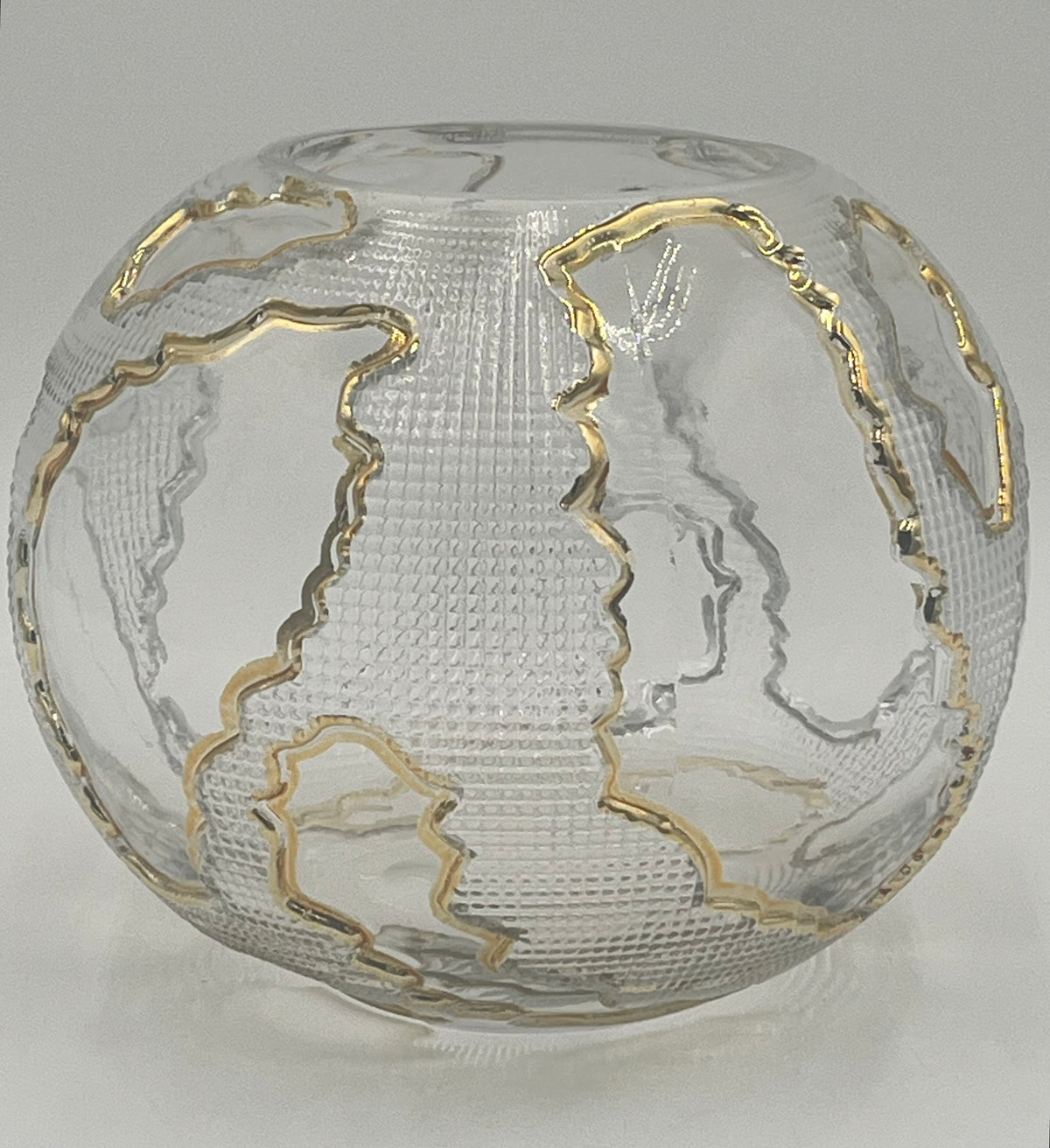 The Lumen Globe 6.5x3.5 Op by Floral supplies Point is a round, clear glass vase with a textured surface and gold-outlined continents, creating a sculptural globe effect that highlights landmasses against the transparent background.