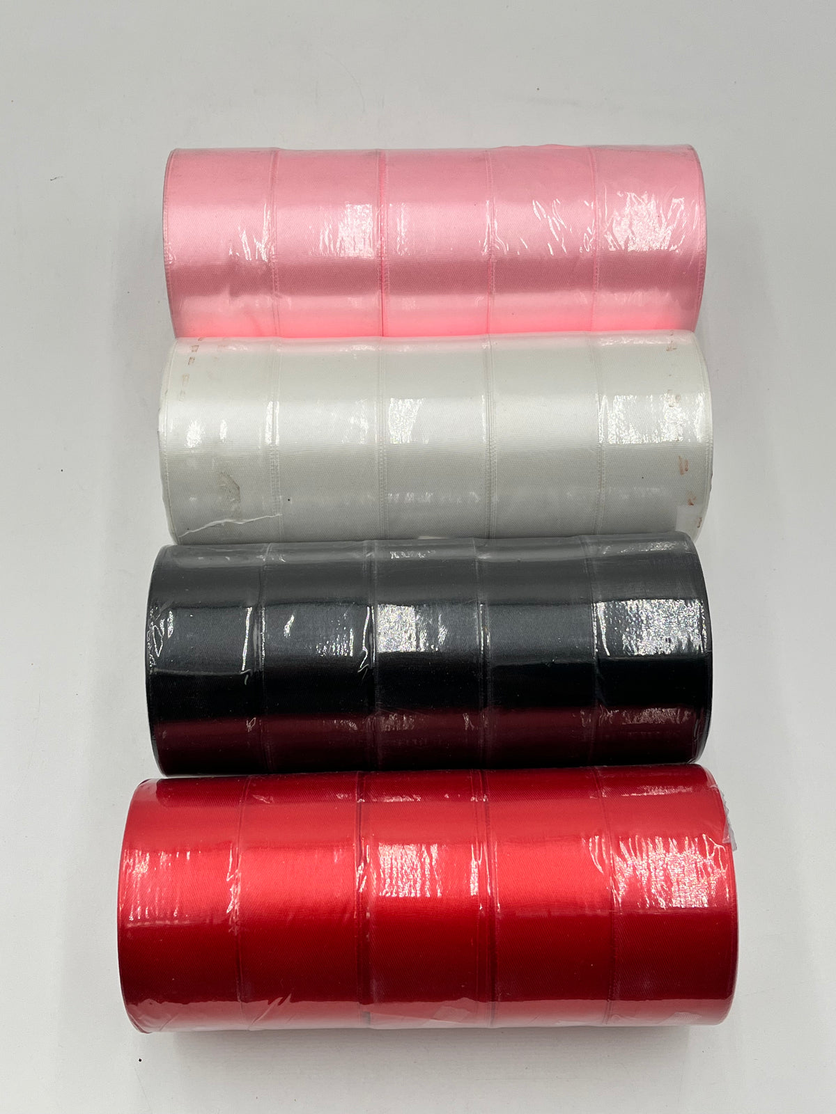 Satin ribbon rolls 1.5" & 2" x 25 yards in Red, Pink, White & Black. Sold individually or in packs by floralsuppliespoint1.com.
