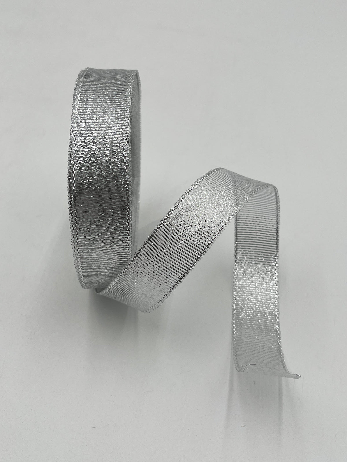 Silver polyester ribbon roll in 1” x 25 yards, ideal for floral design, gifts and crafts. Sold individually by floralsuppliespoint1.com.