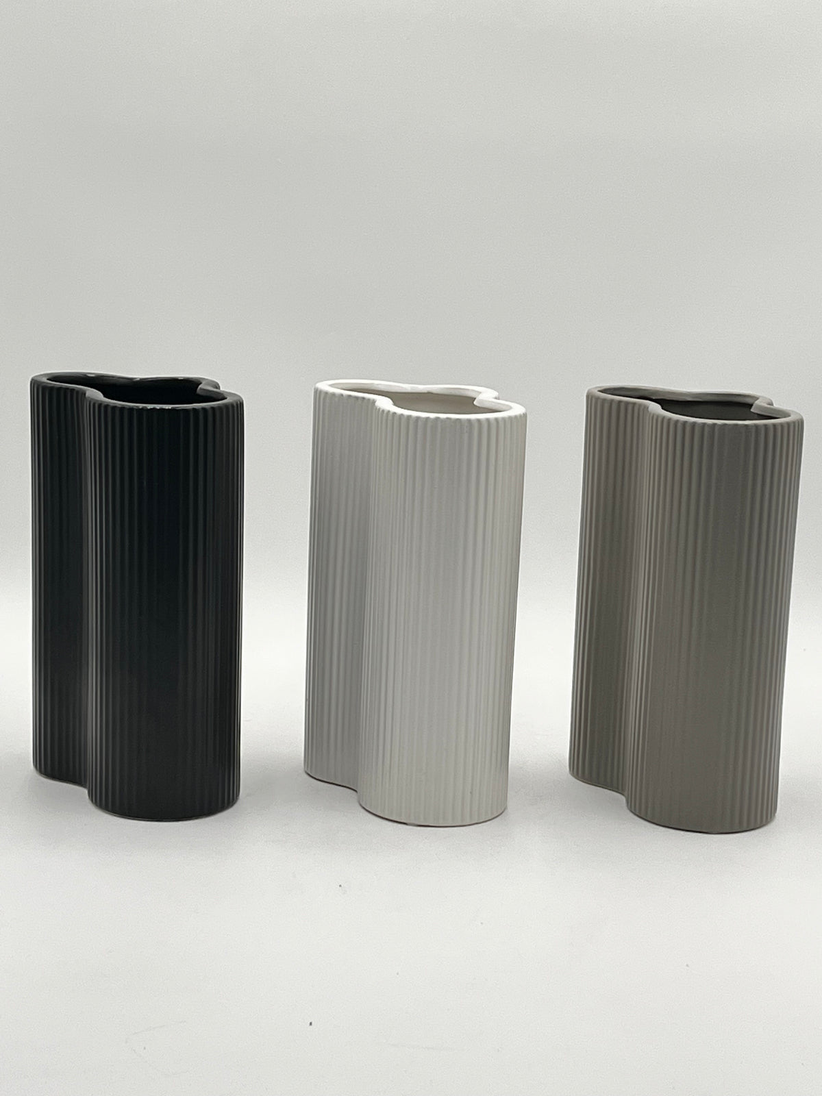 Waveline Core ceramic vases in Matte Black, White, and Grey with ribbed design, sold by floralsuppliespoint1.com. Each vase measures 9" x 5" and weighs 2.30 lbs, perfect for modern floral arrangements.